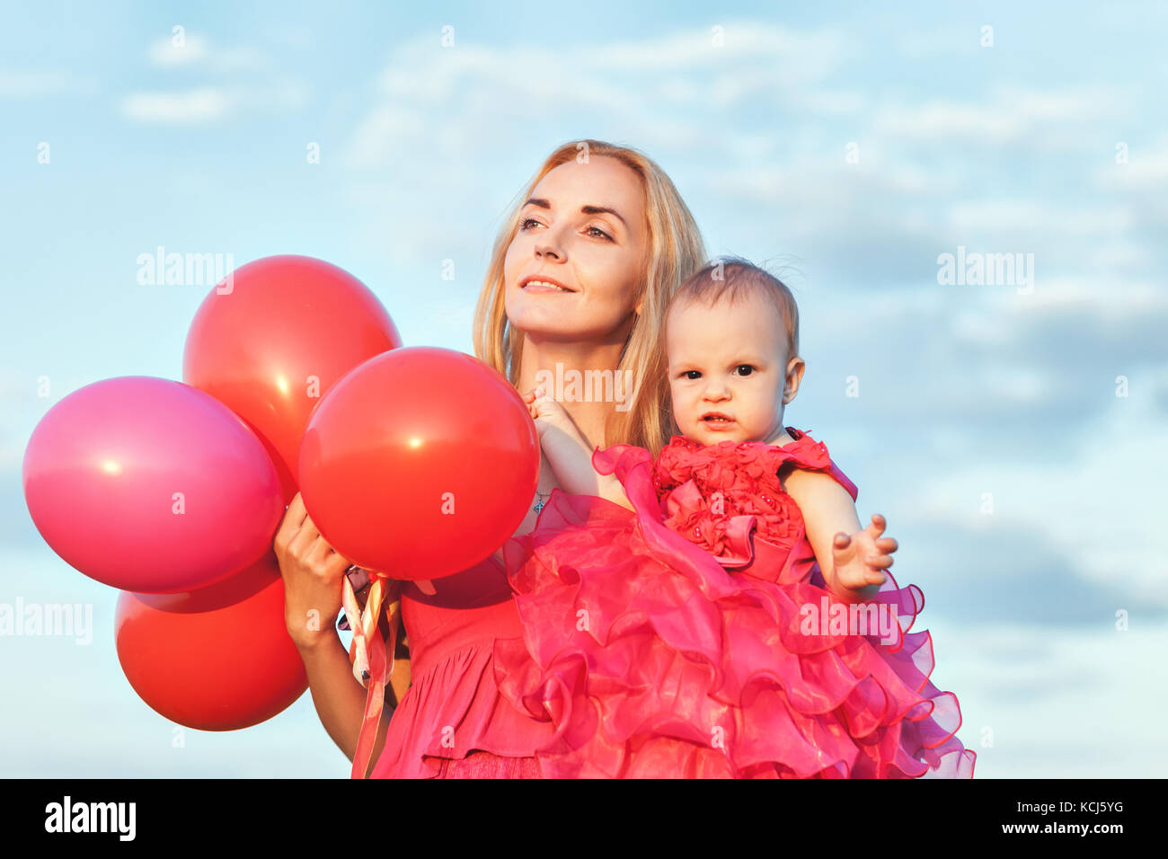 Maman est titulaire d'une fille et un tas de ballons dans ses bras Banque D'Images
