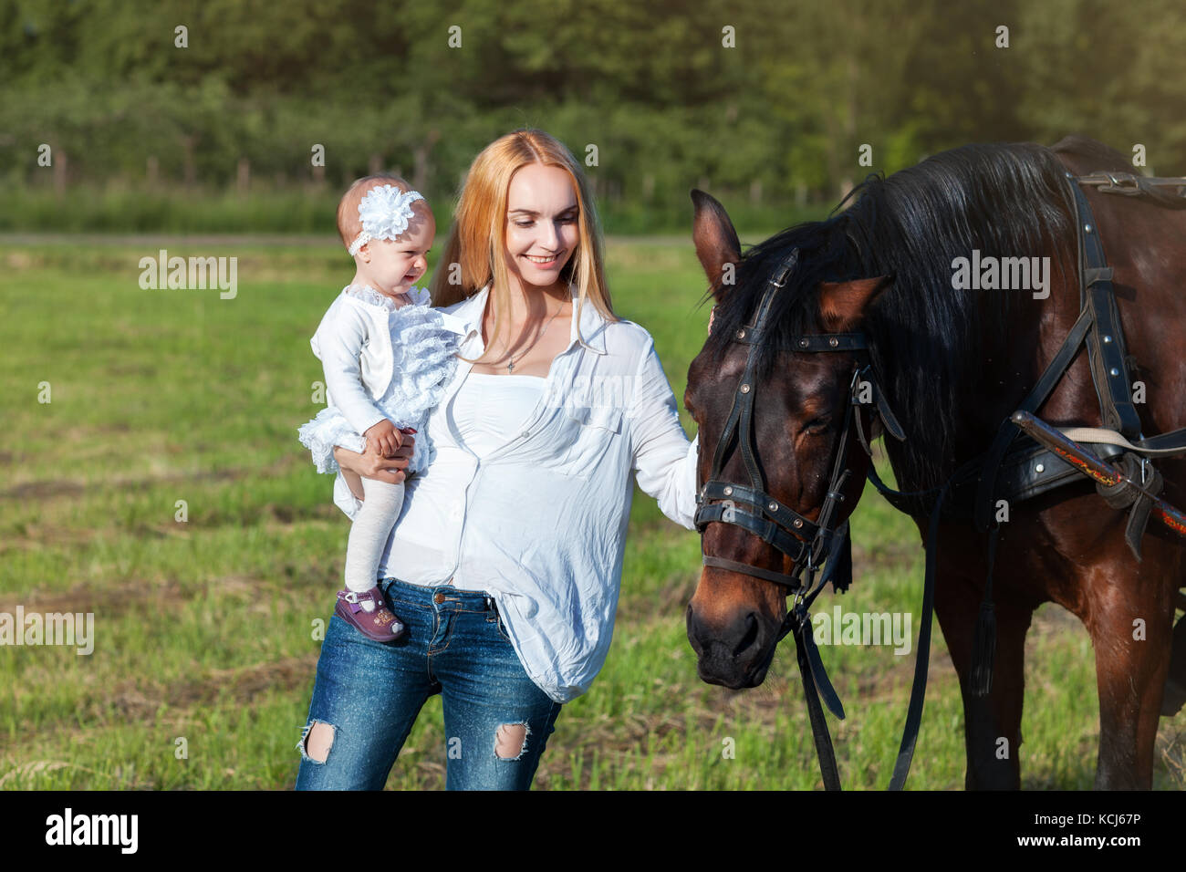 Maman et sa petite fille dans un pré à proximité d'un cheval Banque D'Images