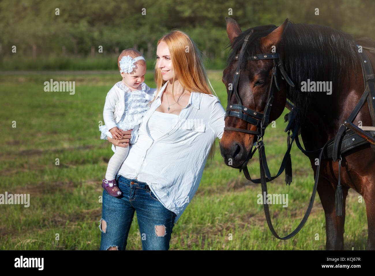 Mère et fille debout près d'un cheval. maman cherche dans la distance Banque D'Images