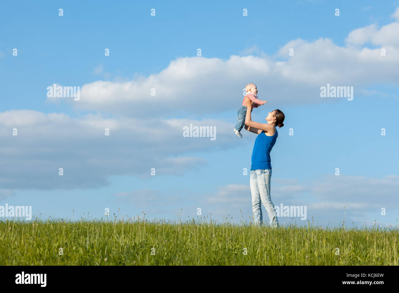 Maman et sa fille sur une prairie contre le ciel. mère fille jette Banque D'Images