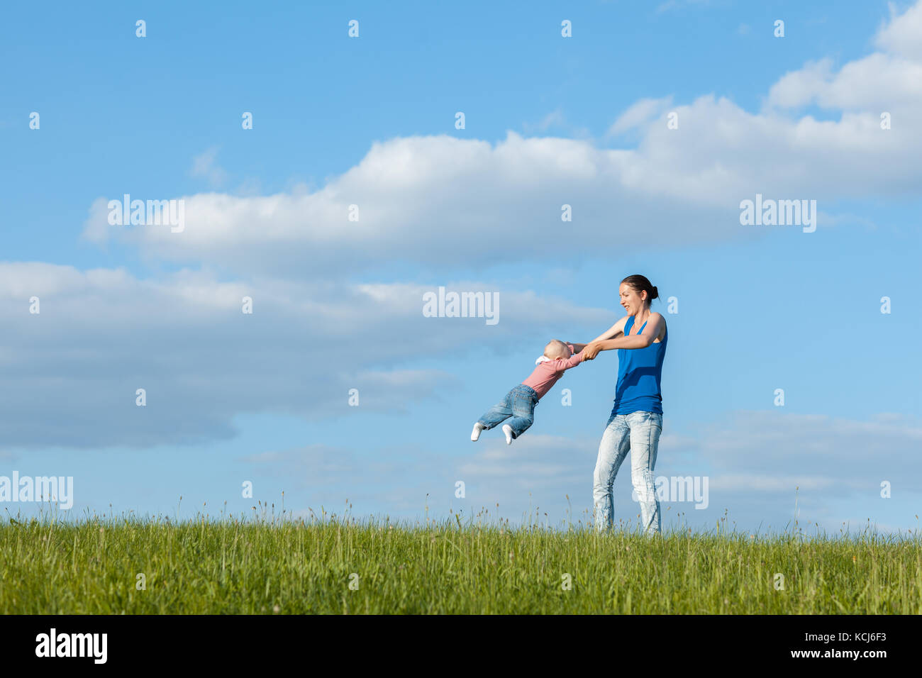 Maman et sa fille sur une prairie contre le ciel. maman tourne fille Banque D'Images
