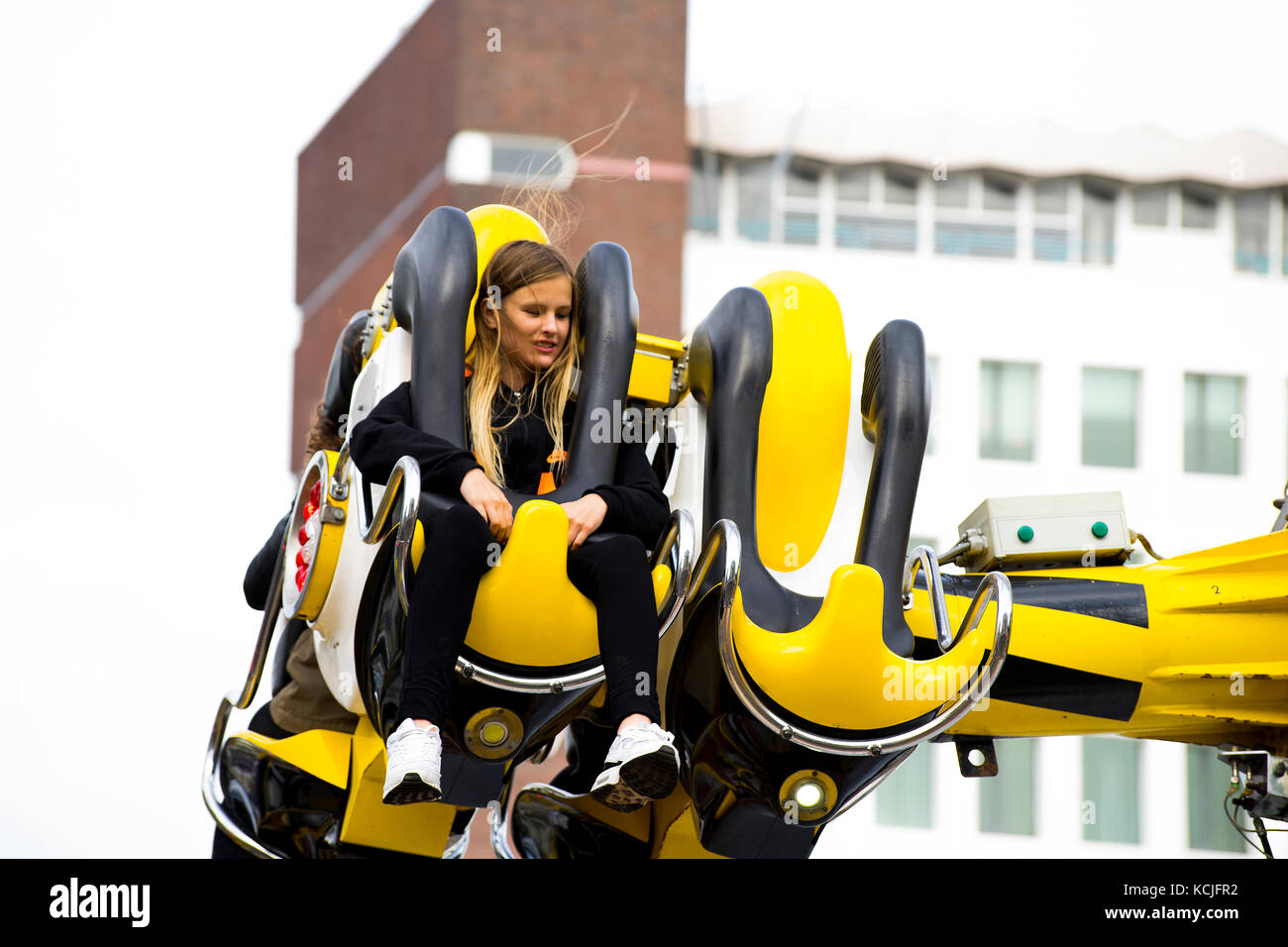 Leiden, Pays-Bas 3 octobre 2017. La foire locale parc d'attractions avec manèges avec une jeune fille assise dans un éditorial d'attraction ride. Banque D'Images