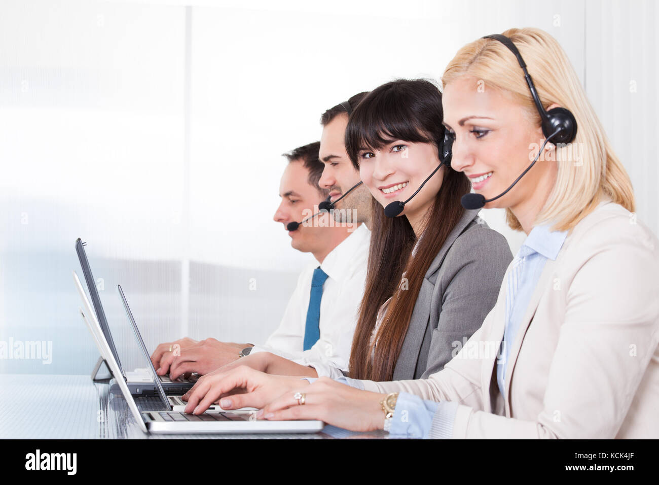 Happy business people working on laptop in office Banque D'Images