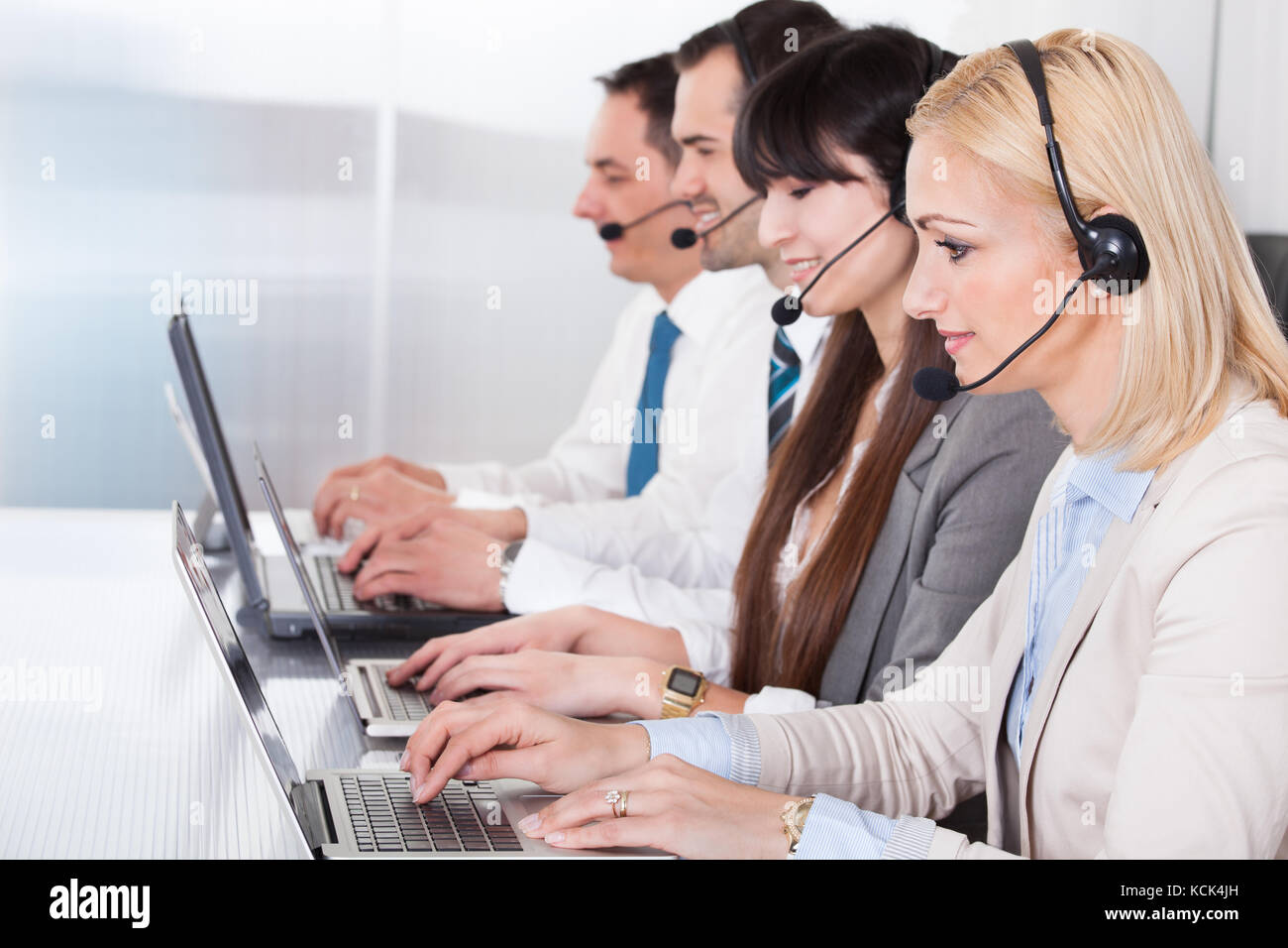 Happy business people working on laptop in office Banque D'Images