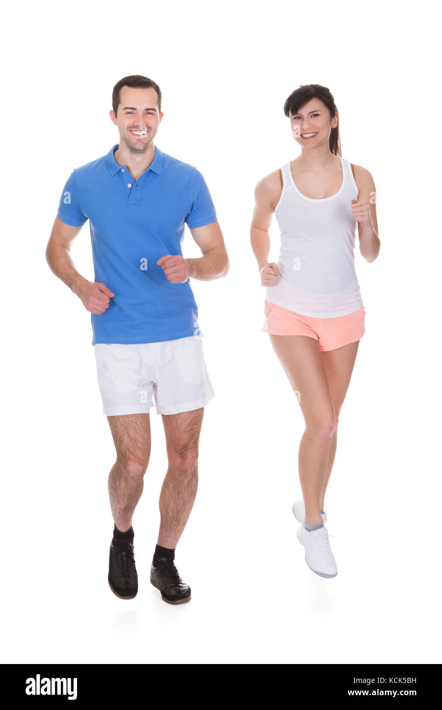 Happy Young Couple Jogging Over White Background Banque D'Images