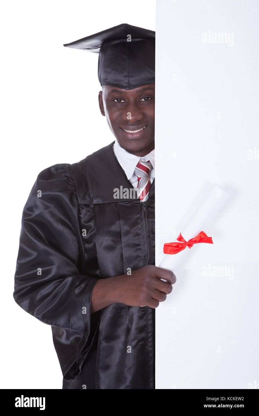 Jeune Diplôme Man Holding Empty Billboard sur fond blanc Banque D'Images