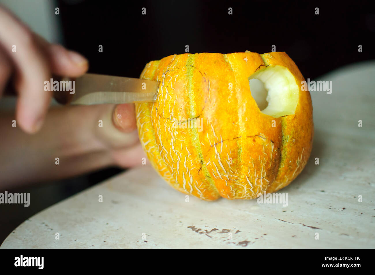 Halloween inhabituelle de melon, processus de découpe, couteau et hommes. focus sélectif et flou. Banque D'Images