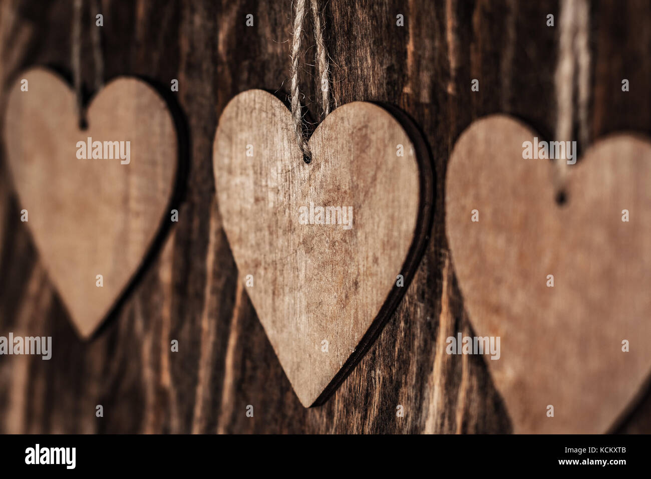 Le Cœur brun en bois avec corde sur fond de bois de près. Banque D'Images