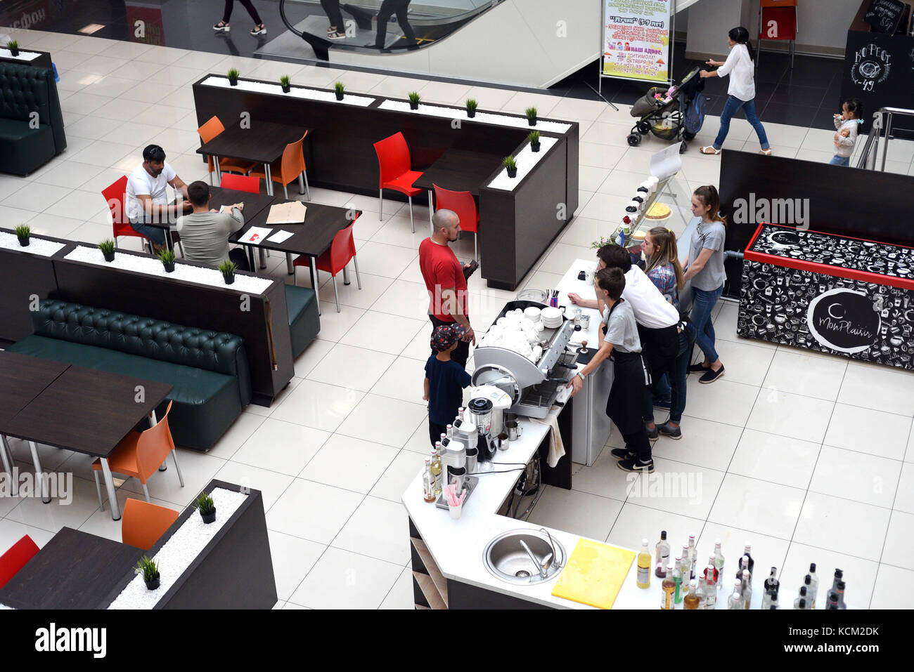 Jeune homme et son enfant parler avec le personnel dans un café-bar moderne Banque D'Images