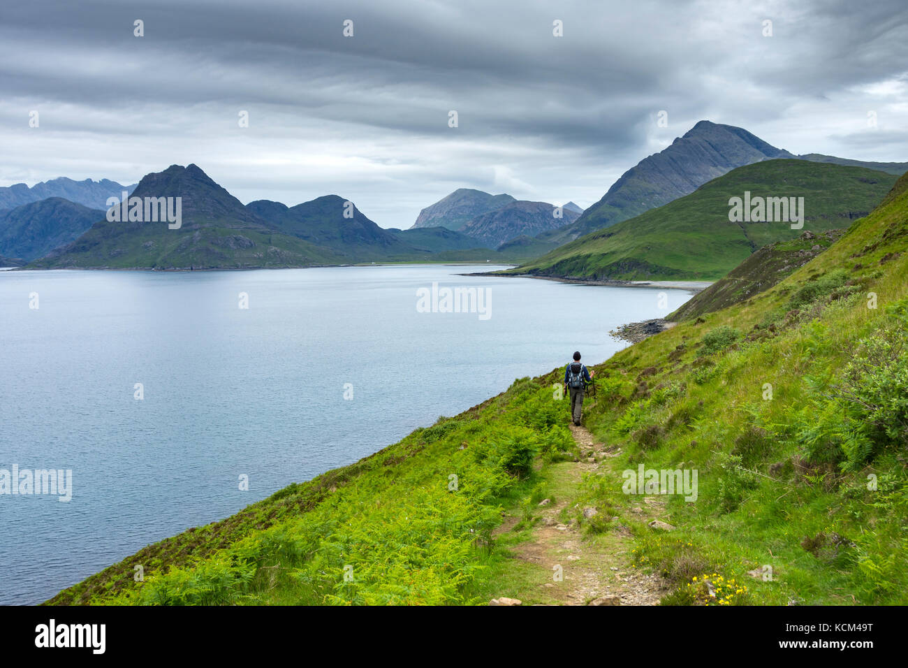 Un marcheur sur le sentier côtier d'Elgol à Camasunary, aux côtés du Loch Scavaig, de l'île de Skye, en Écosse, au Royaume-Uni. Banque D'Images