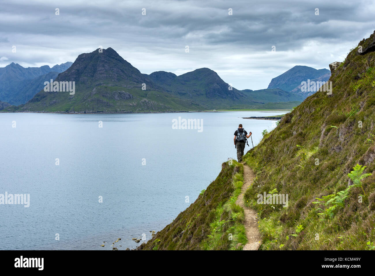 Un marcheur sur le chemin côtier d'Elgol à Camasunary, à côté du Loch Scavaig, île de Skye, Écosse, Royaume-Uni. Sgurr na STRI à gauche et Marsco à droite. Banque D'Images