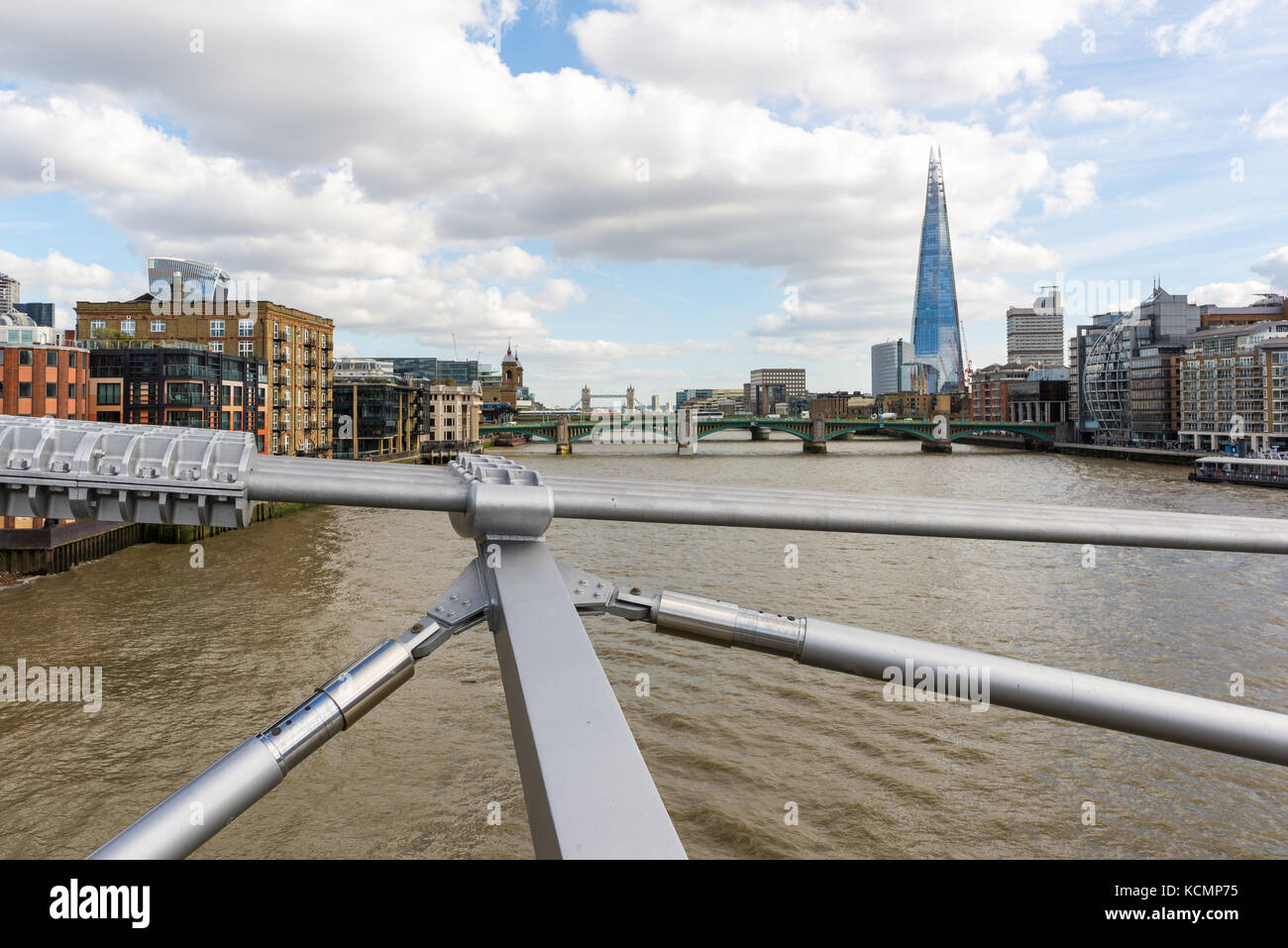 Câbles d'argent et de béquilles du millénaire pont suspendu au-dessus de la Tamise, Londres, Angleterre, Royaume-Uni, avec rivière et le fragment dans l'arrière-plan. Banque D'Images