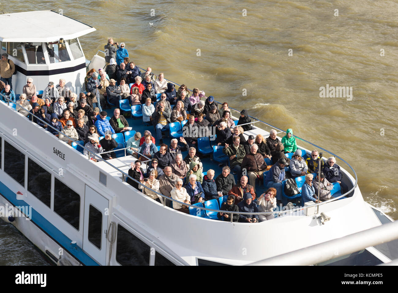 Les touristes et les voyants sur le haut d'un pont d'un croiseur de la rivière, sur la Tamise, Londres, Angleterre, Royaume-Uni, alors qu'il passe sous le pont du Millénaire. Banque D'Images