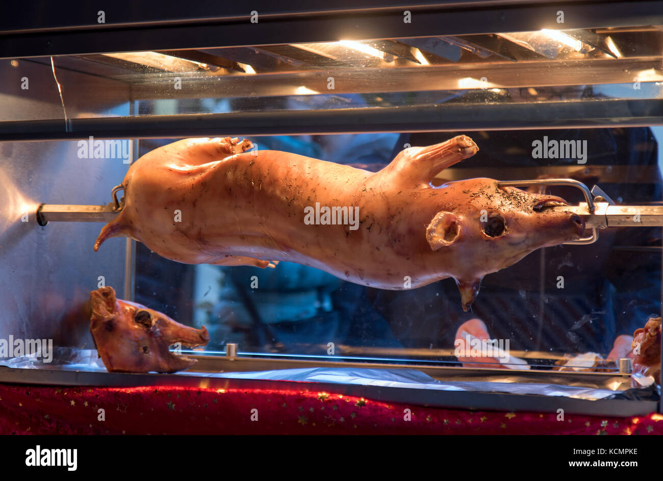 Le cochon tourne à la broche. séle est rôti dans le four en verre sur le  marché. street vente de viande de porc. cochon grillé Photo Stock - Alamy