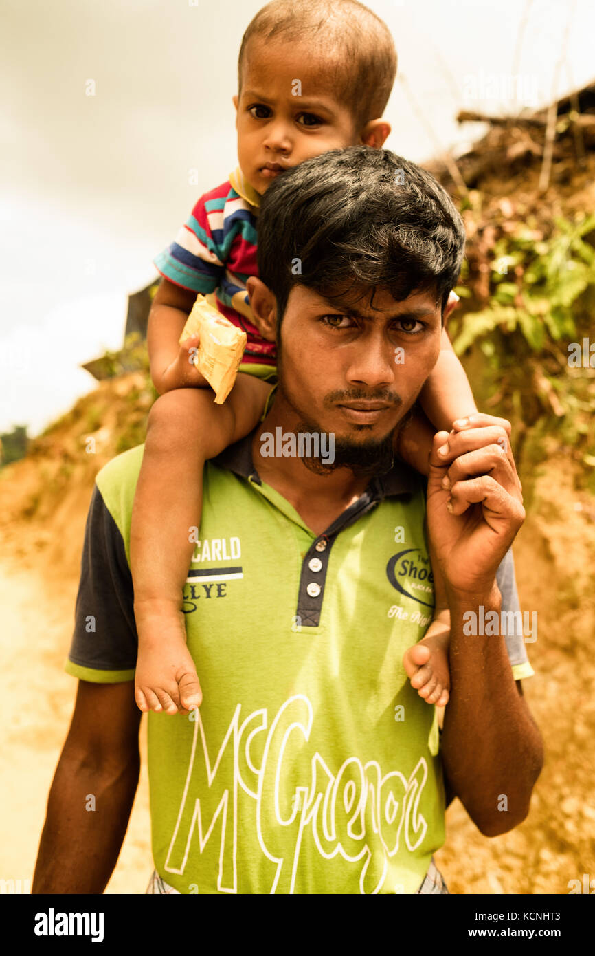 Le père porte son fils dans un camp de réfugiés. Cox's Bazar (Bangladesh). On estime à 429 000 personnes d'avoir récemment fui de l'autre côté de la frontière Banque D'Images
