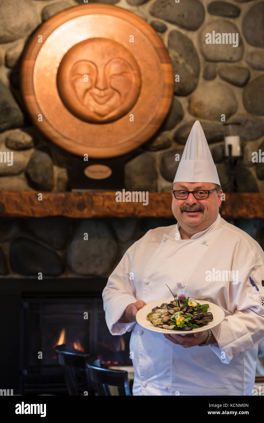 Un chef dans son restaurant de luxe présente un plat de fruits de mer, la vallée de Comox, Canada Banque D'Images