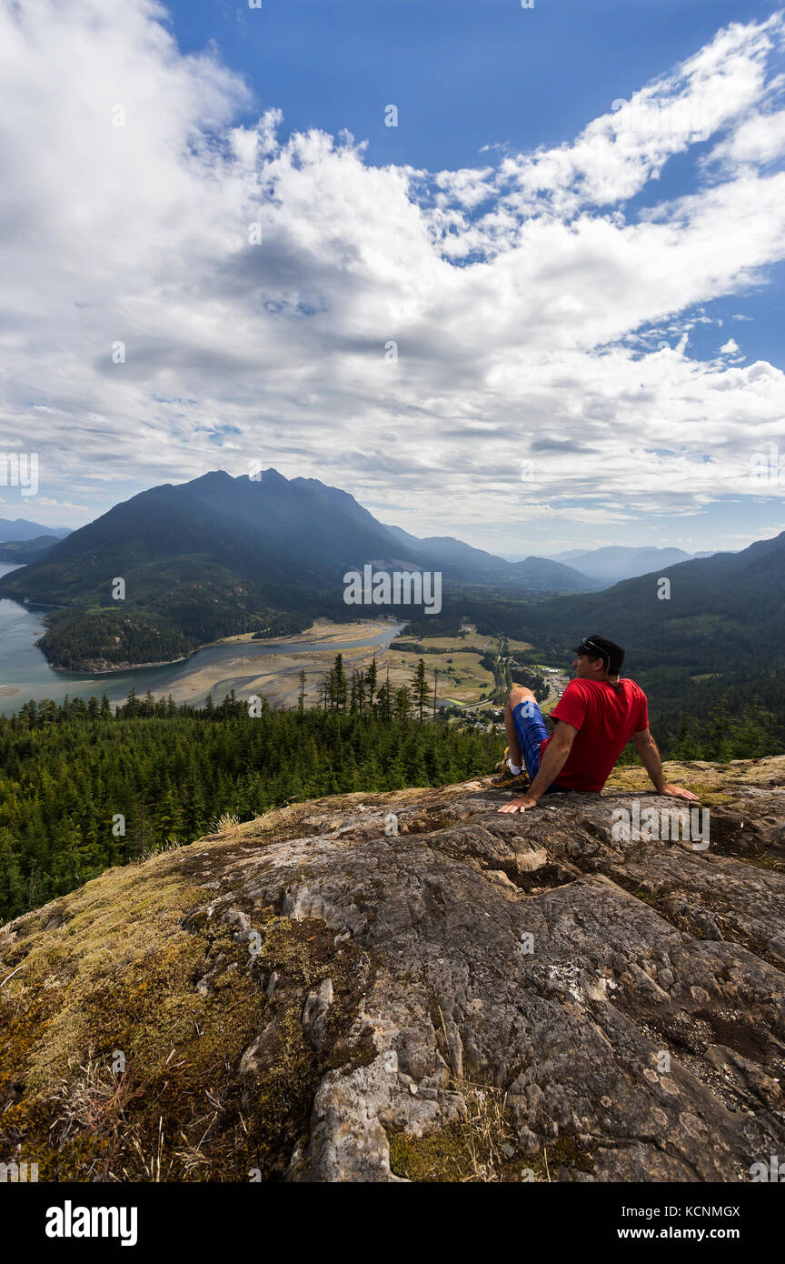 Un randonneur est récompensé avec une vue dominante de Kelsey Bay et l'estuaire de la rivière d'un point de vue haut au-dessus de la vallée, Sayward, île de Vancouver Banque D'Images