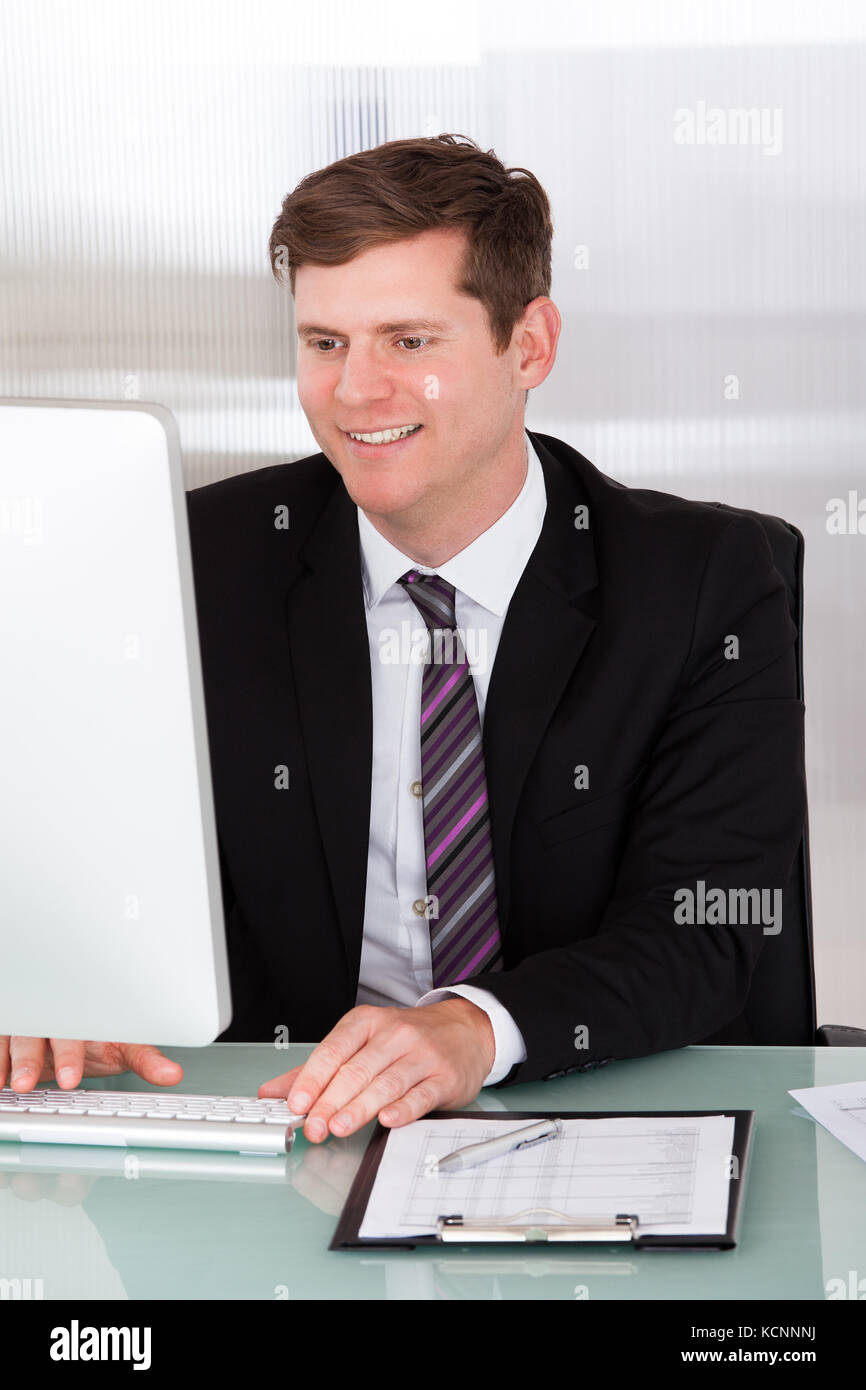 Portrait of happy businessman working at office Banque D'Images
