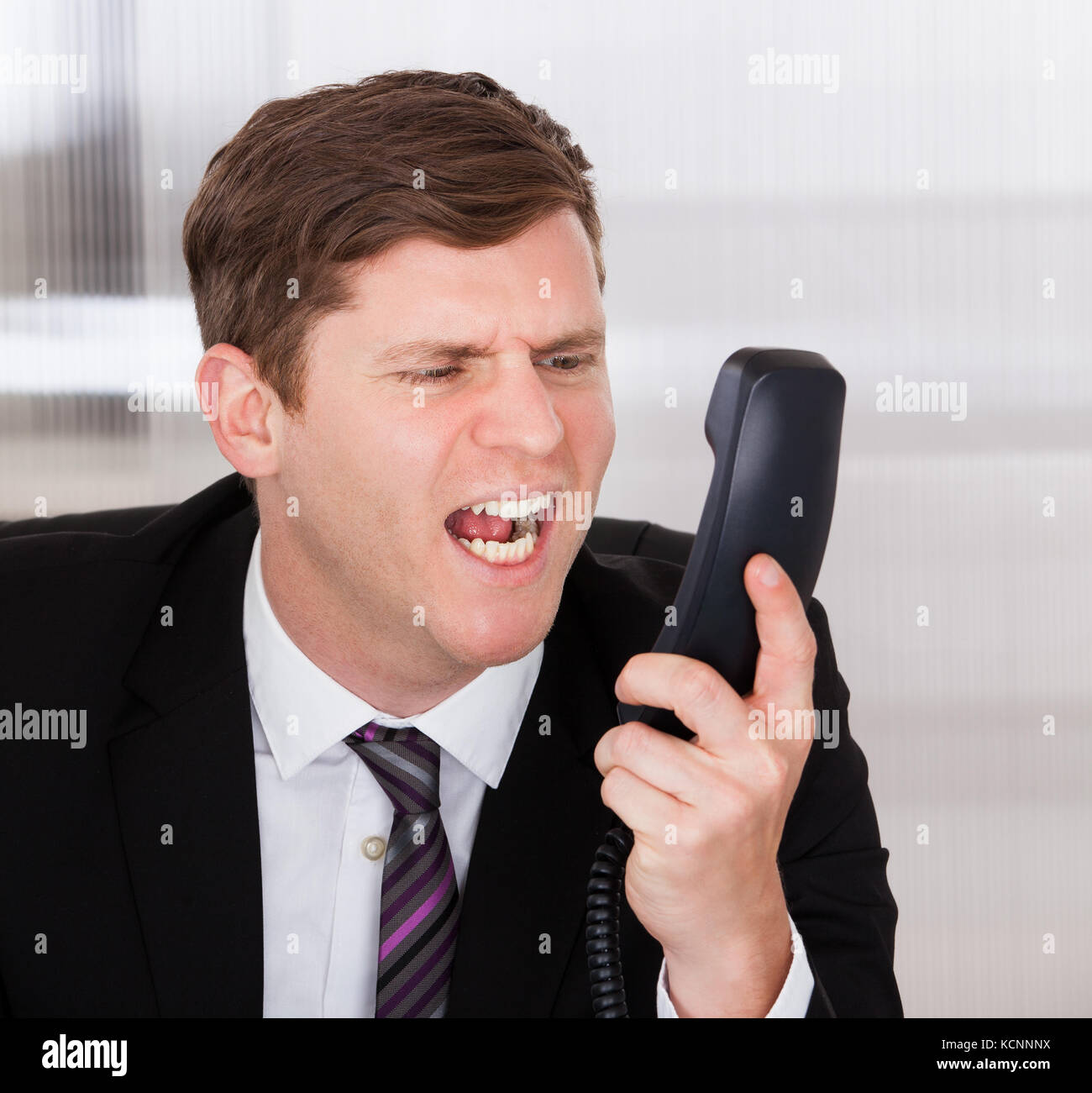 Portrait d'homme en colère crier sur téléphone in office Banque D'Images