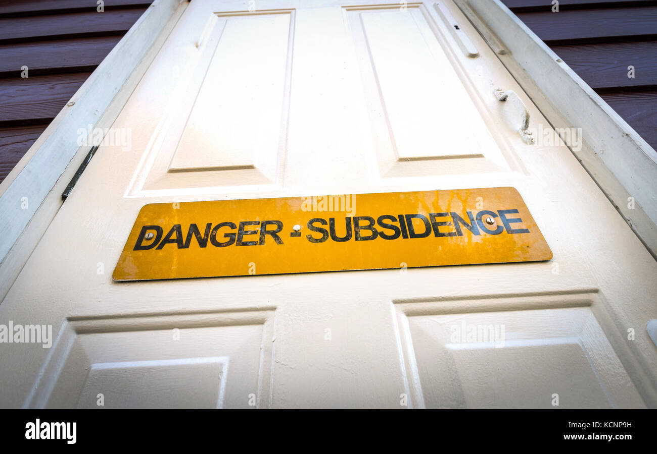 Panneau d'avertissement de subsidence sur la porte avant d'une propriété en bord de mer dans le Hampshire, au Royaume-Uni Banque D'Images Panneau d'avertissement de subsidence sur la porte avant d'une propriété en bord de mer dans le Hampshire, au Royaume-Uni Banque D'Images