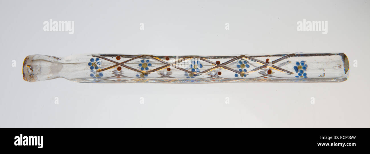 Flacon de parfum en verre transparent en forme de tube avec un motif floral complexe et un bouchon. Cette pièce vintage reflète la verrerie du début du XXe siècle et le design de bouteille de parfum. Banque D'Images