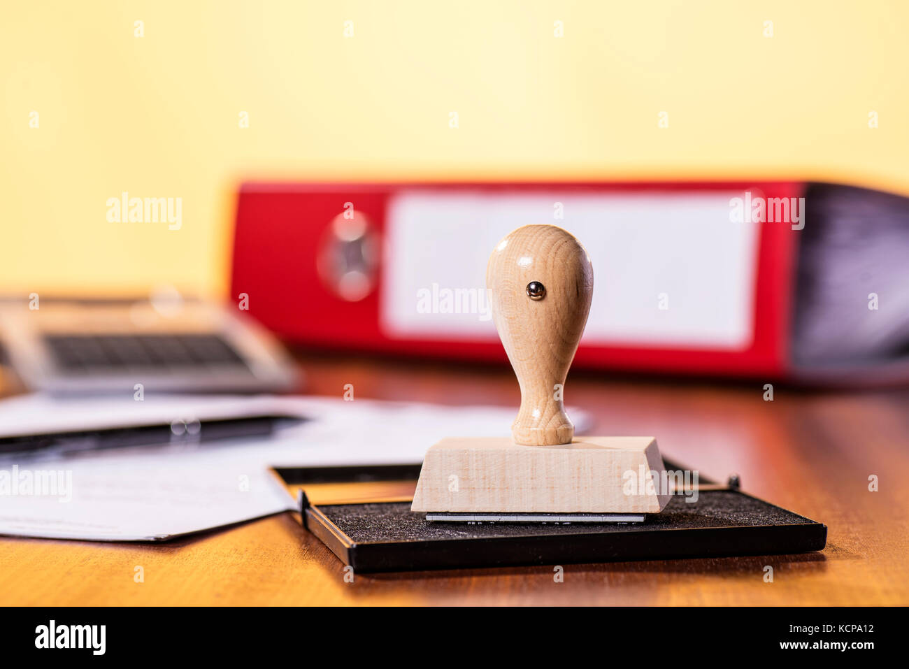 Bureau avec dossier, timbres, calculatrice et un document. Banque D'Images