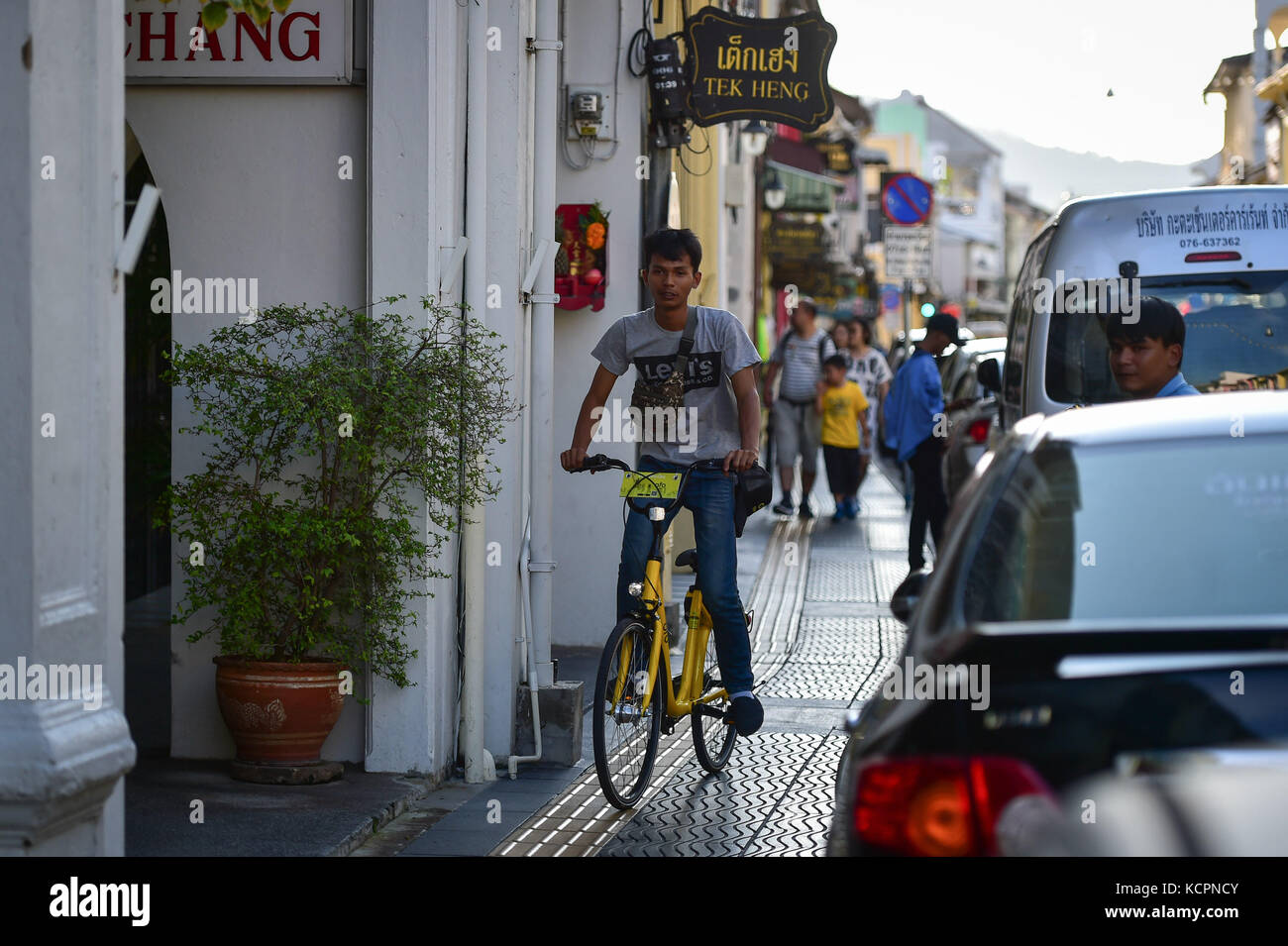 Phuket, Thaïlande. 5 octobre 2017. Un homme monte un vélo de partage ofo dans une zone commerciale de Phuket, Thaïlande, Oct. 5, 2017. La société chinoise de partage de vélos sans quai ofo a fourni plus de 1 000 vélos dans les endroits clés de Phuket fin septembre et a offert un essai gratuit d'un mois sans frais de dépôt. Maintenant, le service de partage de vélos a profité aux résidents locaux et aux touristes. Les frais de service réguliers d'OFO seront facturés à 5 Baht par 30 minutes d'utilisation, avec des frais de dépôt de 99 Baht. Crédit : Li Mangmang/Xinhua/Alamy Live News Banque D'Images