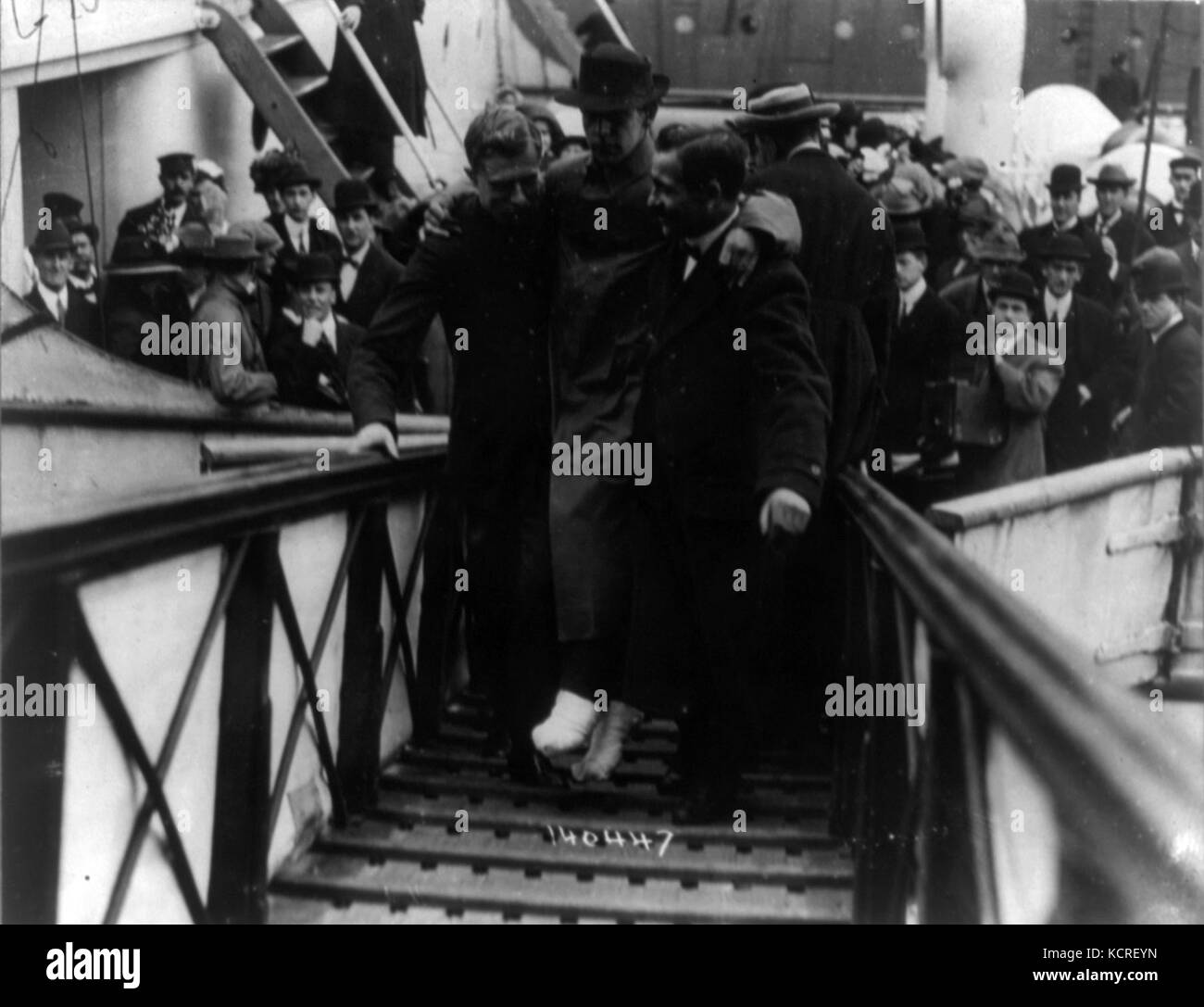 Cette photographie historique représente Harold bride, l'opérateur sans fil à bord du RMS Titanic, transporté sur une rampe. Il saisit un moment important au lendemain de la catastrophe du Titanic, soulignant son rôle dans cet événement tragique. Banque D'Images