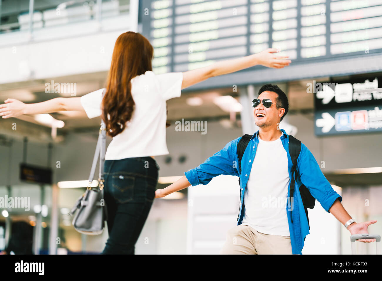 Asian girl picking up son petit ami à la porte d'arrivée de l'aéroport, se félicite de l'étudier ou travailler à l'étranger. jeune couple amour et hug concept Banque D'Images