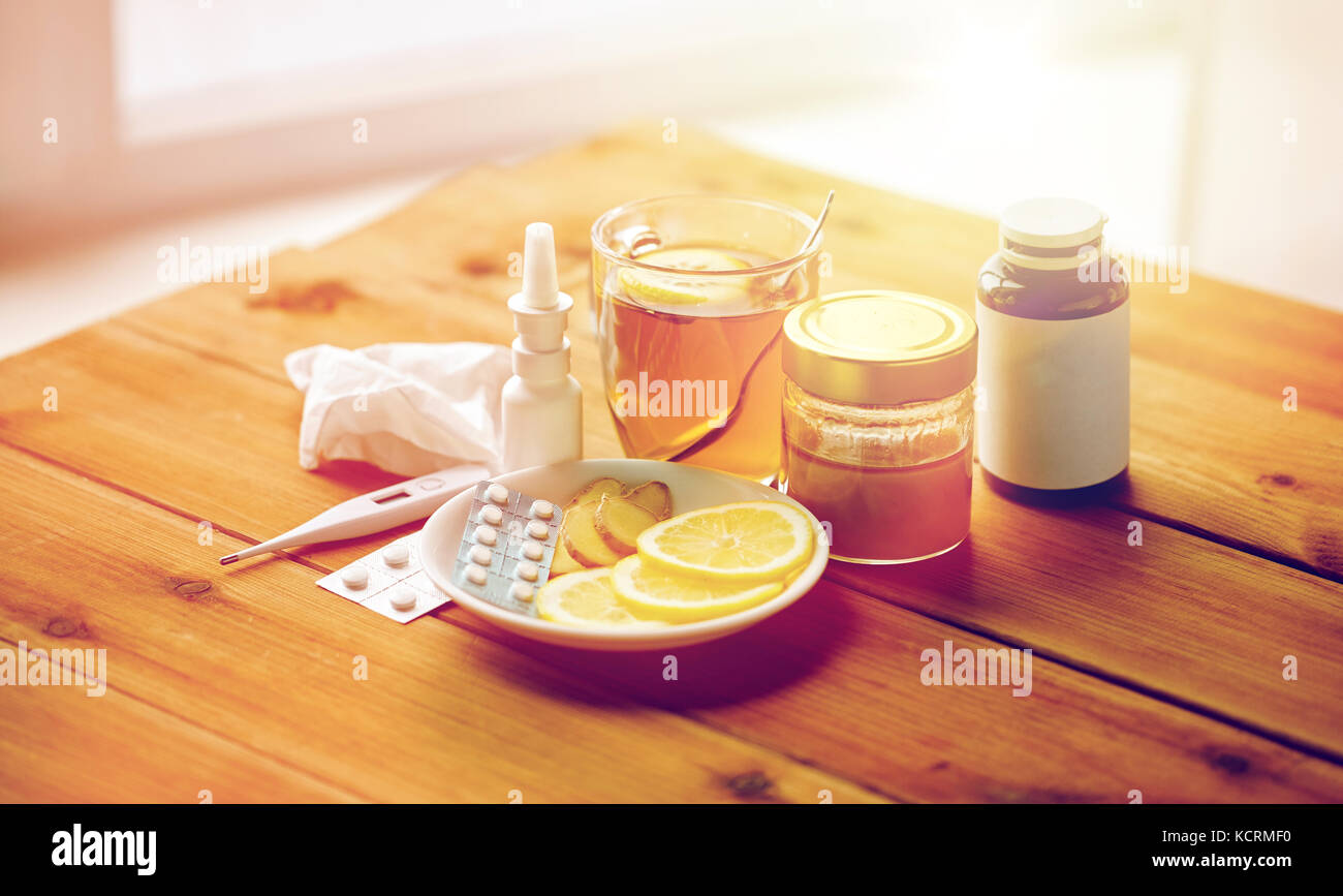 La drogue, thermomètre, le miel et une tasse de thé sur bois Banque D'Images