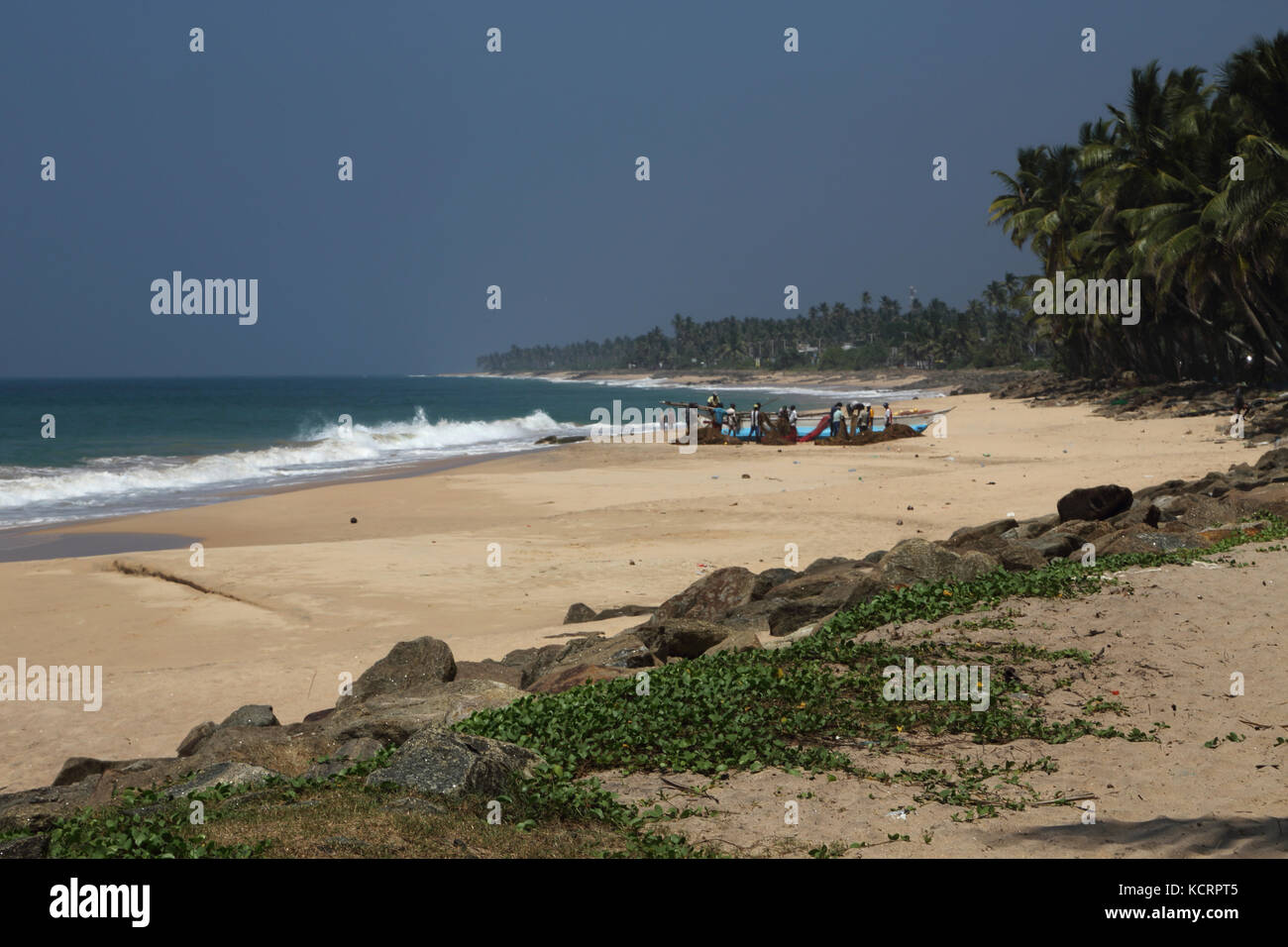 Le sud du Sri Lanka de Hikkaduwa Province pêcheurs tendant des filets par bateau sur la plage Banque D'Images