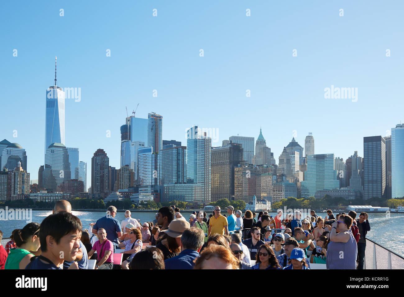 Les gens et les touristes prendre des photos et à la recherche à New York city skyline de ferry boat in a sunny day Banque D'Images