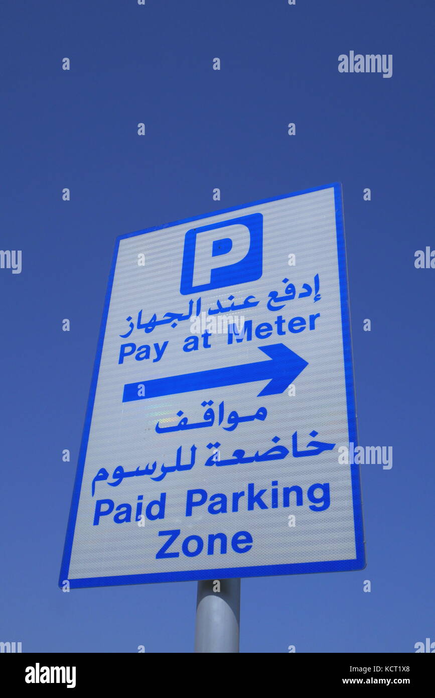Une signalisation routière en arabe et en anglais afin de les aviser qu'ils sont dans une zone de stationnement payant et devrait payer au compteur. Banque D'Images