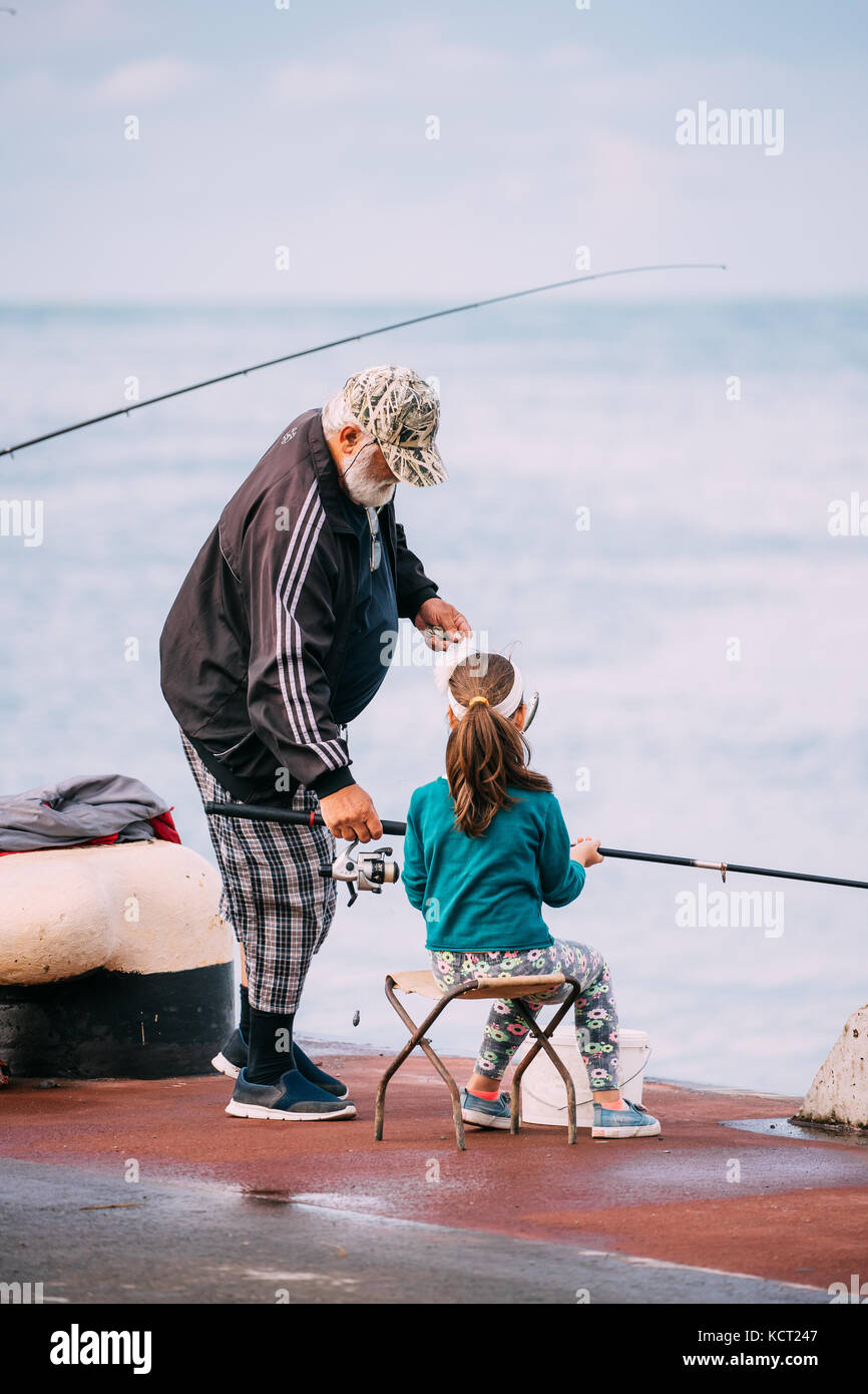Vieil homme pêchant avec sa petite-fille près de Port Dock à Batoumi, Adjara, Géorgie. Banque D'Images