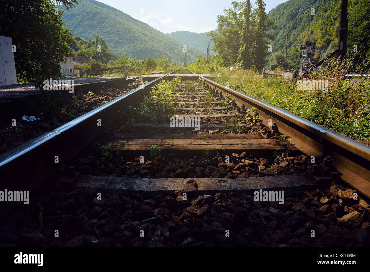 Low angle view of rails de chemin de fer menant à vue, avec des montagnes verdoyantes Banque D'Images