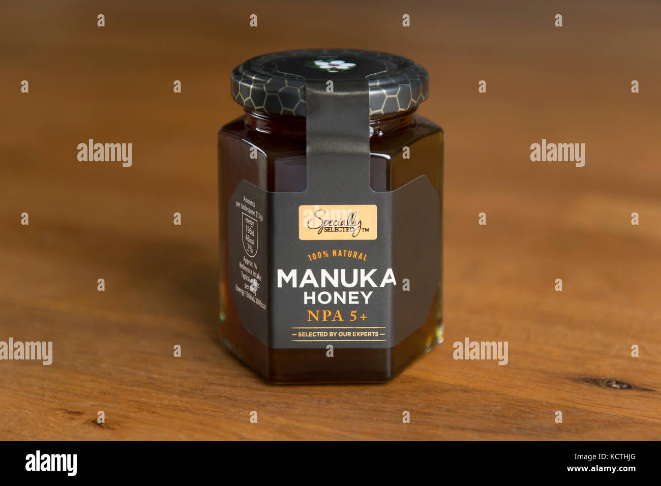 Un pot d'Aldi spécialement sélectionné le miel de Manuka est tourné contre un fond de bois (usage éditorial uniquement). Banque D'Images