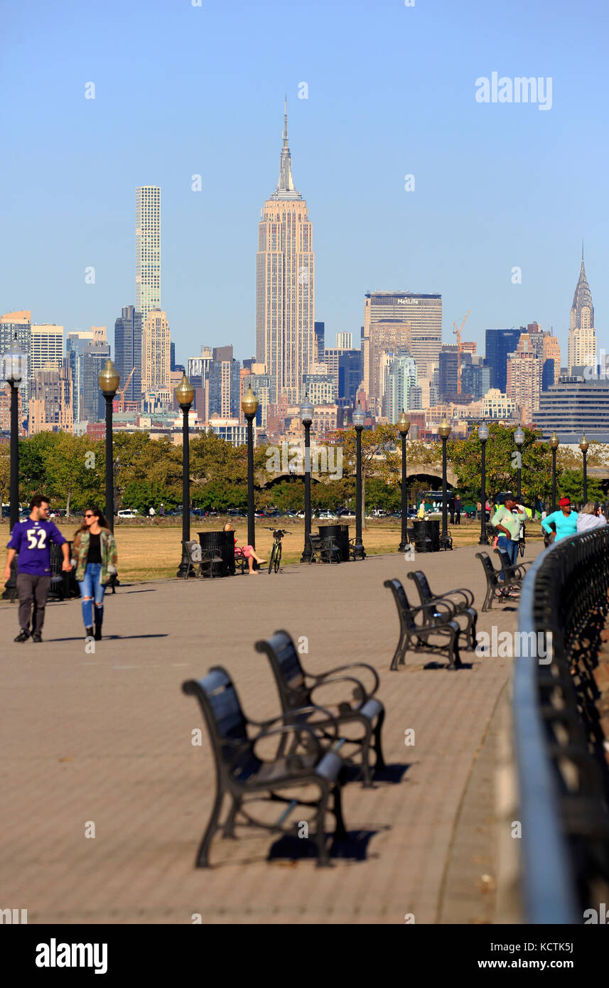 Visiteurs à la promenade du bord de mer de Hudson River dans le parc national Liberty avec le centre-ville de Manhattan à New York et l'Empire State Building en arrière-plan.NJ.USA Banque D'Images