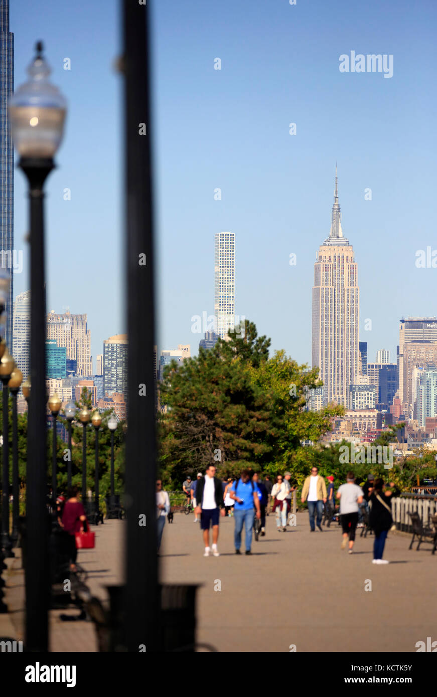 Visiteurs à la promenade du bord de mer de Hudson River dans le parc national Liberty avec le centre-ville de Manhattan à New York et l'Empire State Building en arrière-plan.NJ.USA Banque D'Images