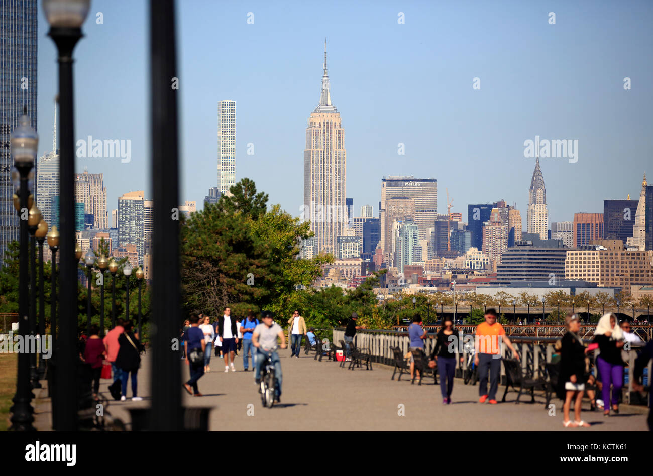 Visiteurs à la promenade du bord de mer de Hudson River dans le parc national Liberty avec le centre-ville de Manhattan à New York et l'Empire State Building en arrière-plan.NJ.USA Banque D'Images