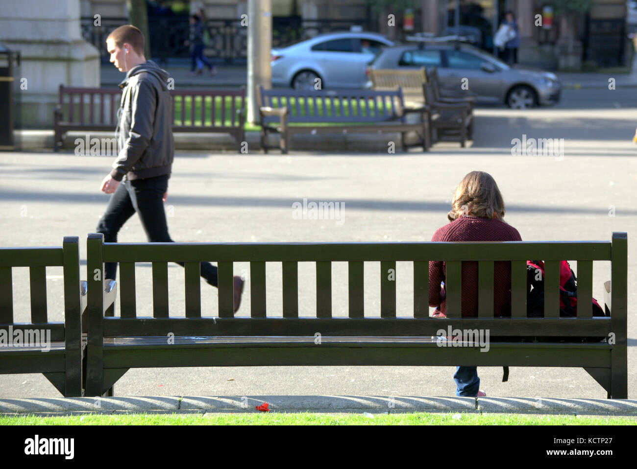 Assis om un banc regarder la vie aller par les touristes George Square Glasgow Banque D'Images