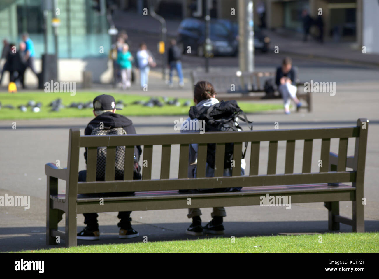 Assis om un banc regarder la vie aller par les touristes George Square Glasgow Banque D'Images