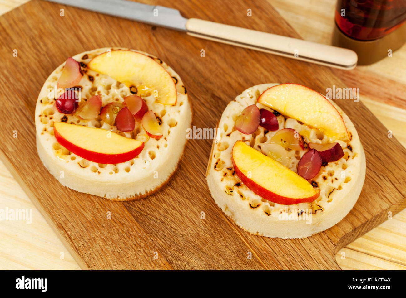Les crumpets frais sur une maquette en tête avec Apple et de raisins et une lumière l'aide de sirop d'érable Banque D'Images