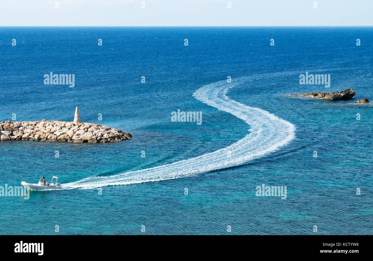 Un petit navire quitte une forme de service que s'il entre dans le port de St Georges près de Paphos à Chypre. Banque D'Images