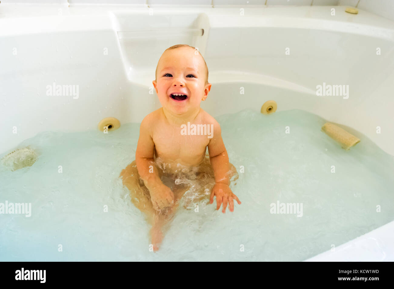 9-mois Garçon jouant dans un bain à remous Banque D'Images