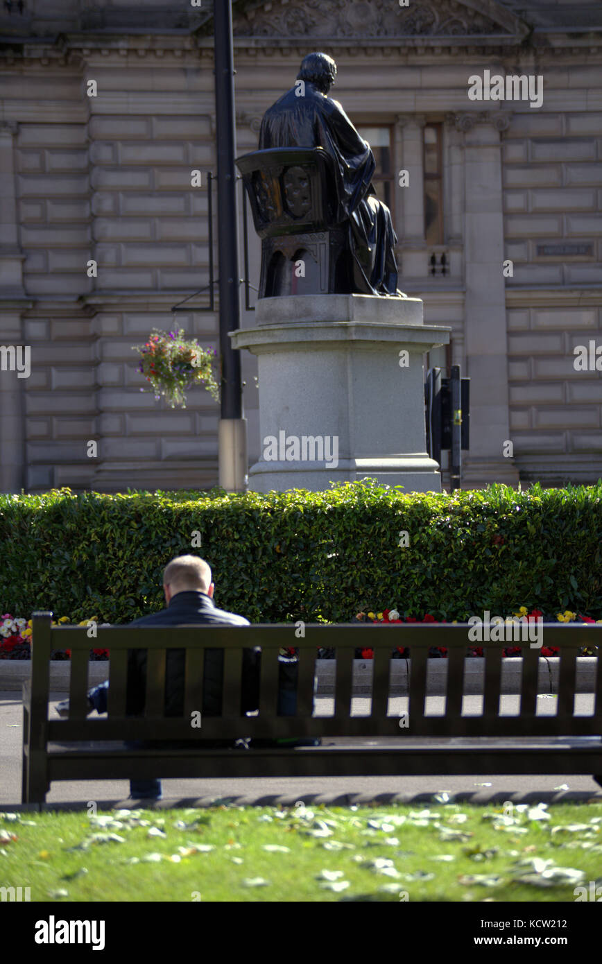 Assis om un banc regarder la vie aller par les touristes George Square Glasgow Banque D'Images