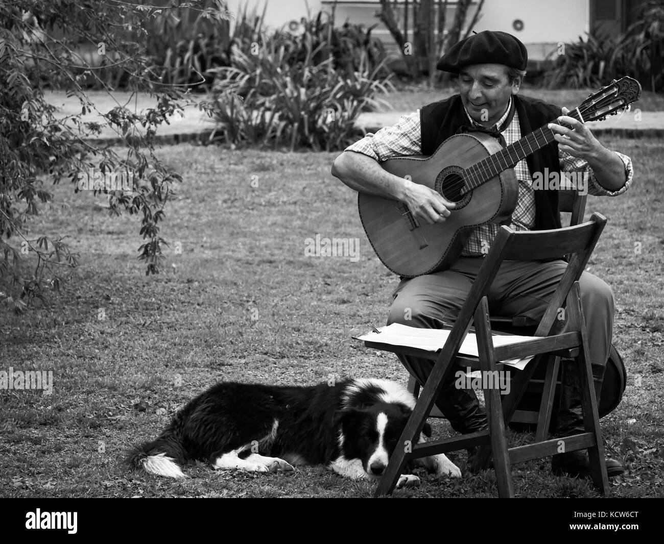 Musicien Gaucho avec guitare et de chien à ses pieds, l'estancia, San Antonio de Areco, nr. Buenos Aires, Argentine Banque D'Images