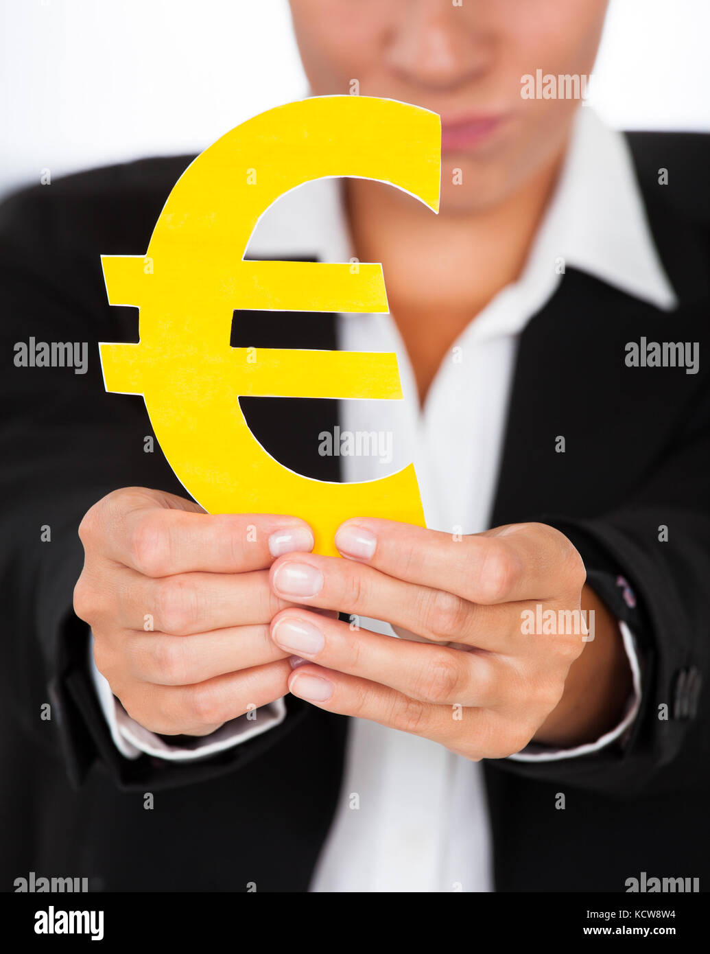 Close-up of hand holding yellow signe euro dans la main Banque D'Images