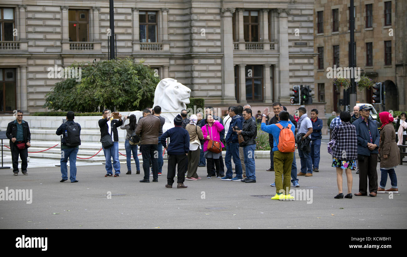 Groupe touristique ou guide de fête photographie prendre des photos George Square Glasgow cénotaphe Banque D'Images