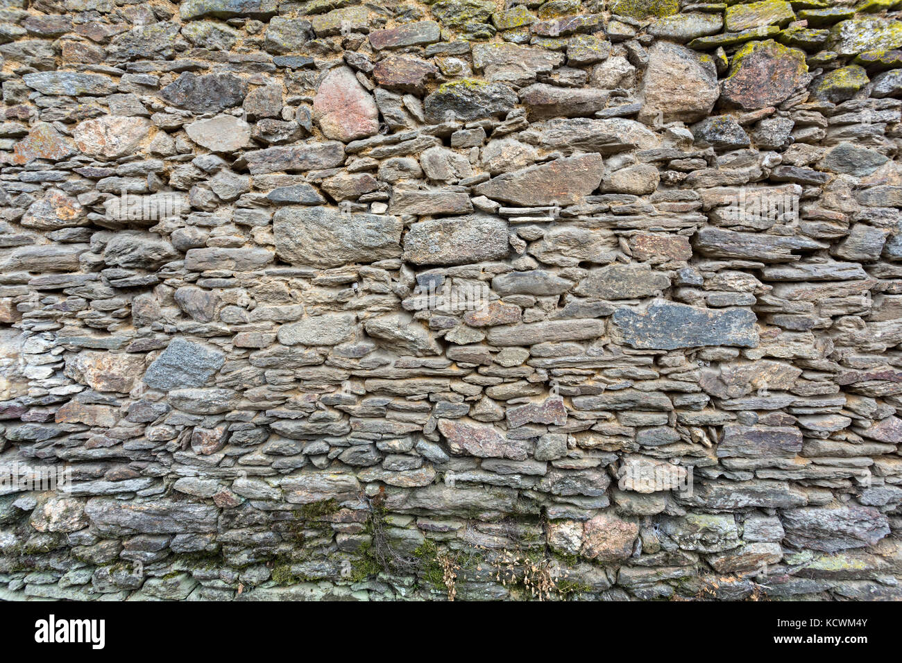 Vue de côté de la structure en pierre grise sur un vieux mur de pierres sèches. Banque D'Images