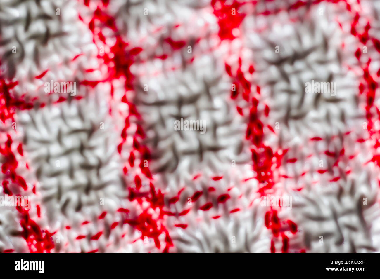 Gros plan, flou, adouci, sur les fils de gauchissement et de trame d'un teacloth rouge et blanc. Résumé rouge Banque D'Images